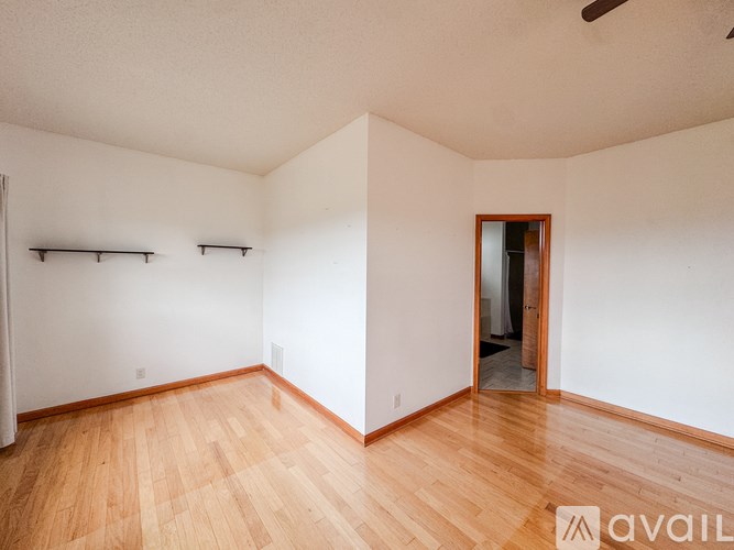Empty room with wooden floors and white walls.