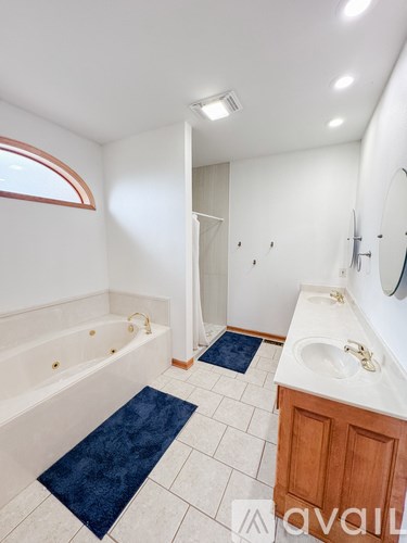 A bathroom with a blue rug on the floor.
