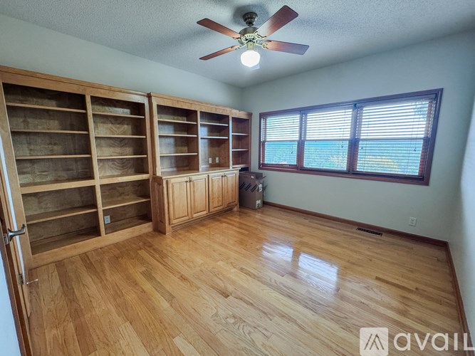 A room with wooden floors and a ceiling fan.
