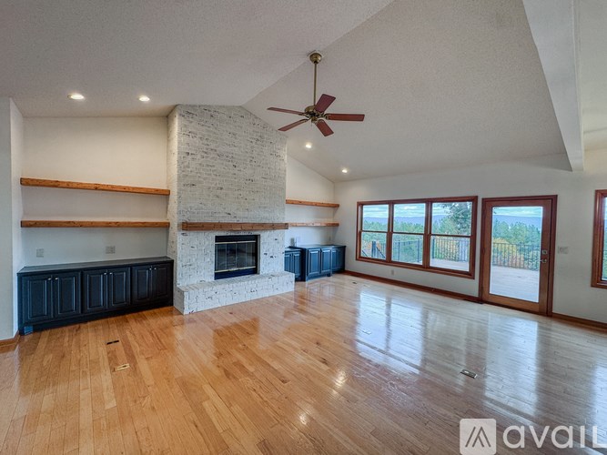 A spacious living room with a fireplace and wooden floors.