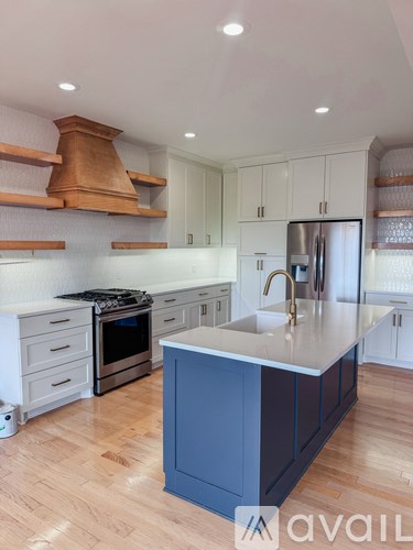 A kitchen with a blue island and wooden cabinets.