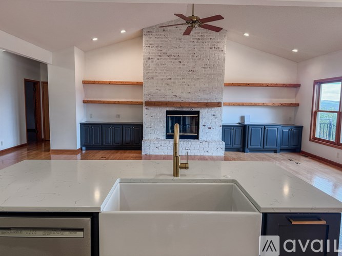 A kitchen with a white marble countertop and a fireplace.