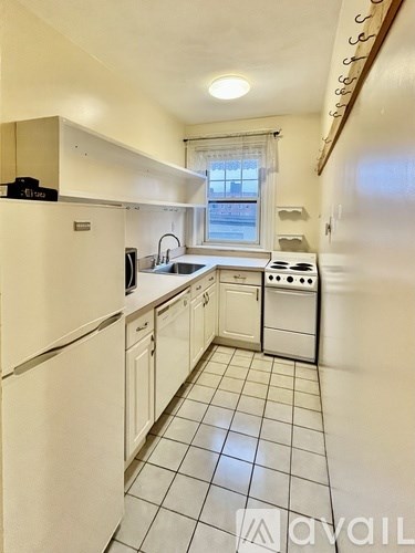 A kitchen with white appliances and white cabinets.