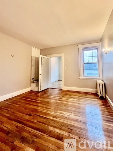 A room with wooden flooring and a window.