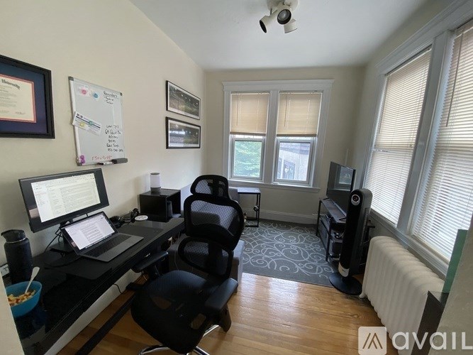 A room with a desk, chair, and computer setup.