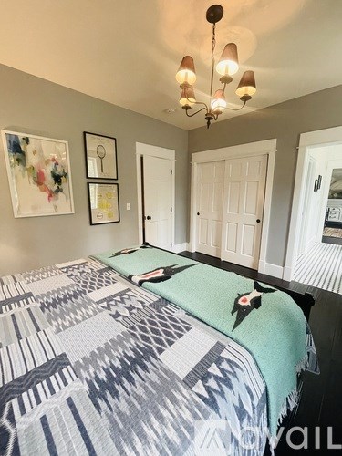 A bedroom with a bed and a chandelier.