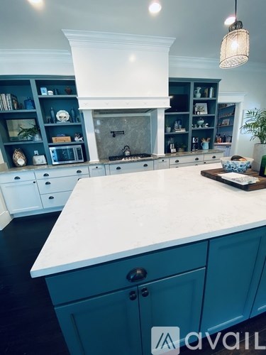 A kitchen with a white countertop and blue cabinets.