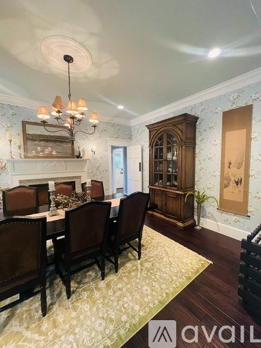 A dining room with a chandelier, a fireplace, and a cabinet.