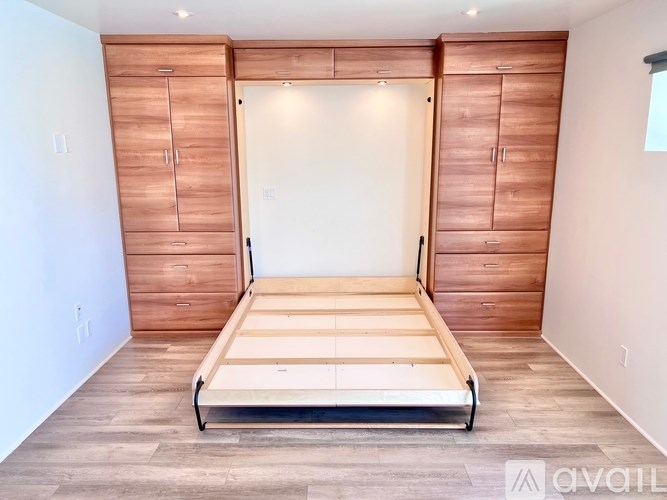 A bedroom with a bed, dresser, and wardrobe.