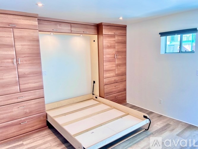 A bedroom with a bed, dresser, and wardrobe.