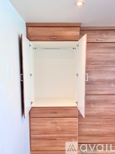 A wooden staircase with a white wall on the left side.