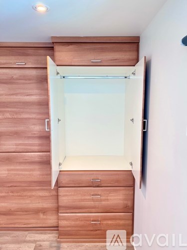 A wooden staircase with a glass door leading to a white room.