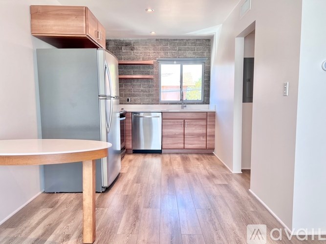 A kitchen with a wooden floor and a brick wall.
