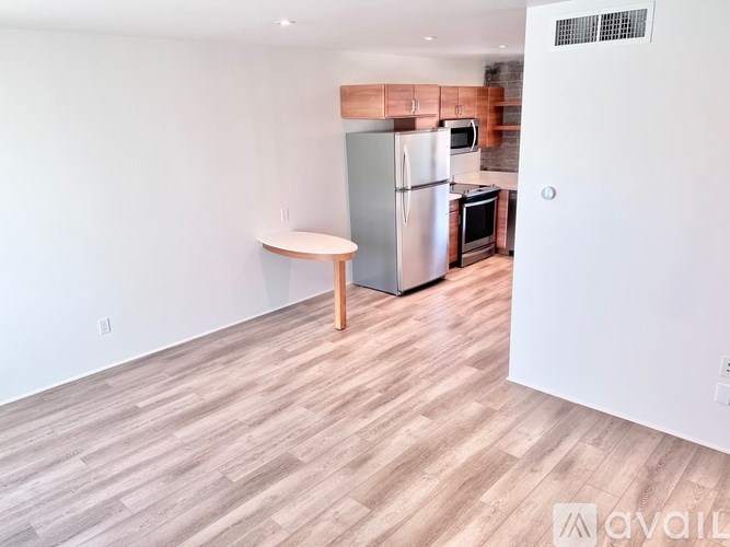 A kitchen with a refrigerator, microwave, and oven.