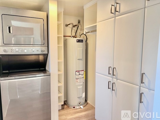 A kitchen with a stainless steel oven and microwave, a white fridge, and a white cabinet.
