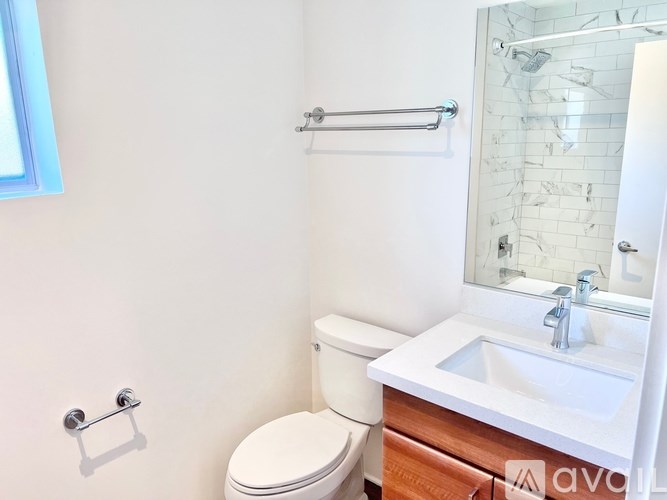A white toilet sits next to a sink in a bathroom.