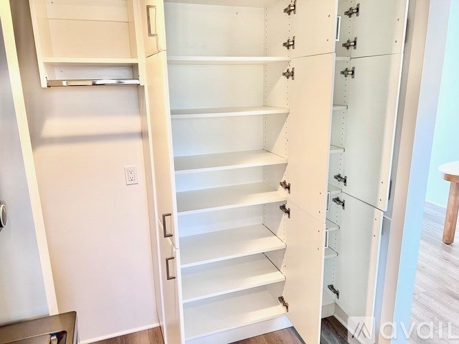 A white, empty staircase with a door on the left and a wall on the right.