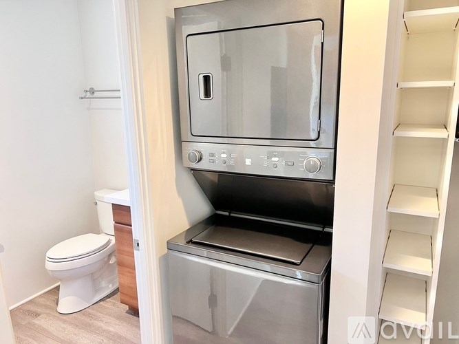 A modern kitchen with a stainless steel oven and a white toilet.