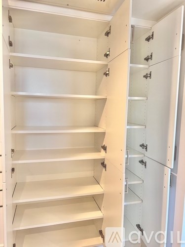 A white shelving unit with multiple shelves and hooks.