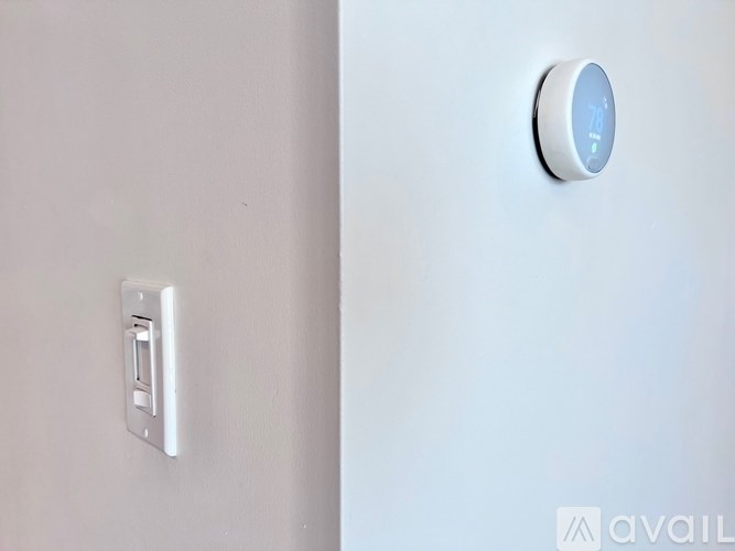 A white light switch and a round light switch on a wall.