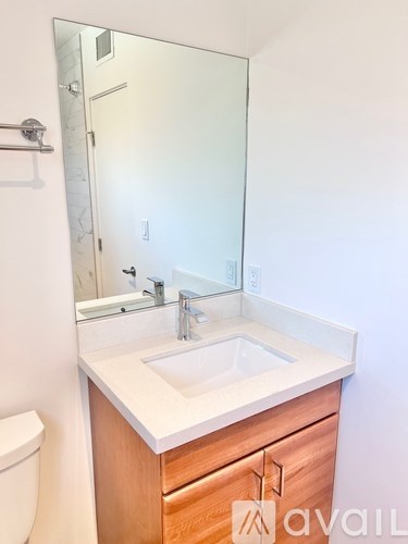 A bathroom with a sink, mirror, and toilet.