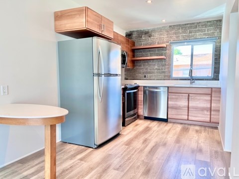 A kitchen with a stainless steel refrigerator and wooden cabinets.