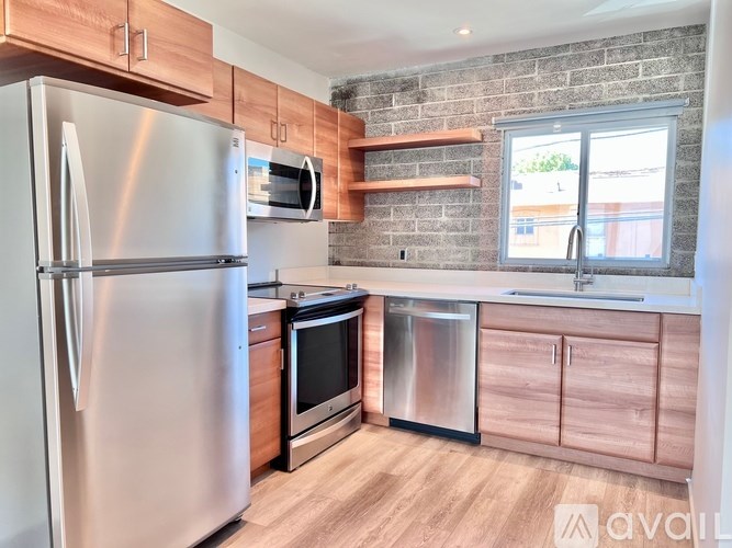 A kitchen with a refrigerator, oven, and microwave.