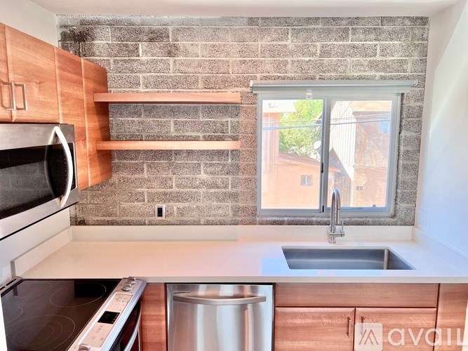 A kitchen with a brick wall and a window.