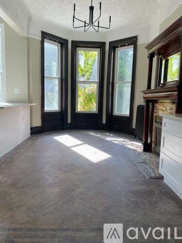 A room with a large window and a chandelier.