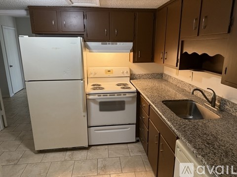 A kitchen with a white refrigerator and a stove top oven.