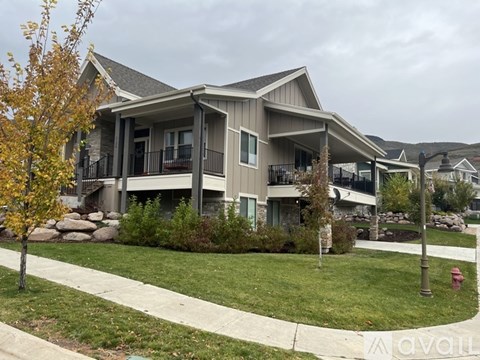A modern house with a grey roof and a balcony.