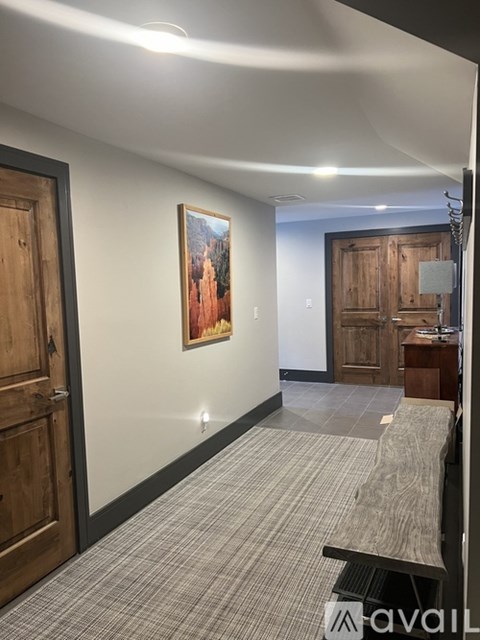A hallway with a bench and a painting on the wall.
