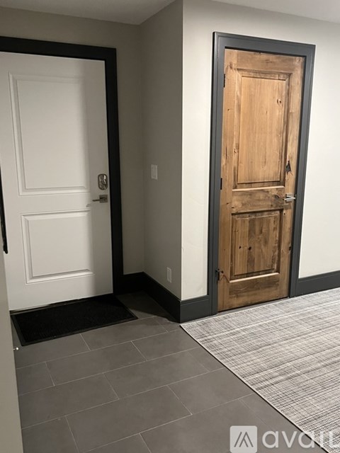 A white door is on the left and a wooden door is on the right.