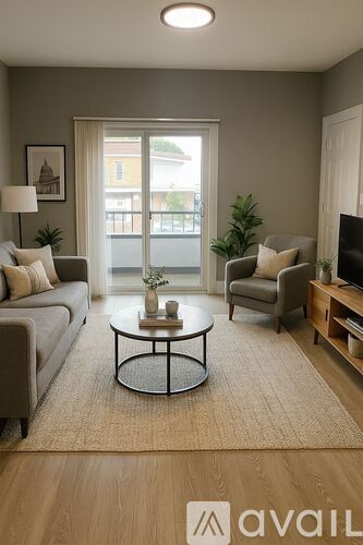 A living room with a grey couch, a coffee table, and a flat screen TV.