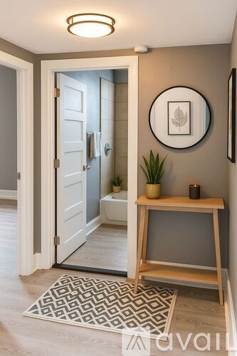 A bathroom with a white door and a round mirror on the wall.