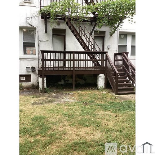 A white building with a wooden staircase outside.