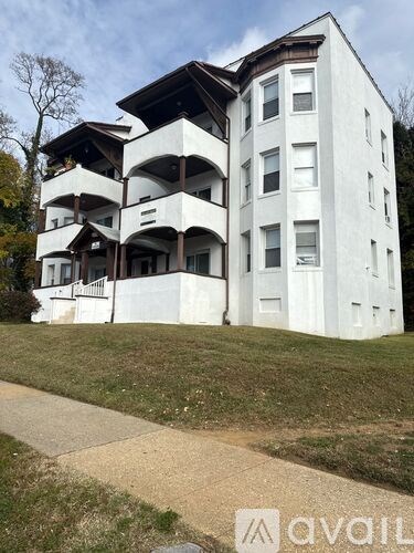 A white building with a brown roof and balconies.