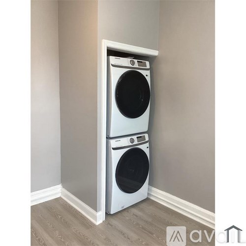 A white front loading washing machine in a laundry room.