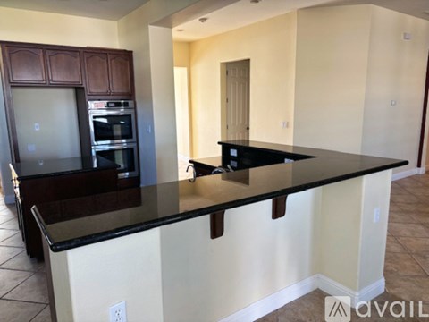 A kitchen with a black countertop and wooden cabinets.
