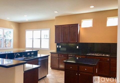 A kitchen with brown cabinets and a black countertop.