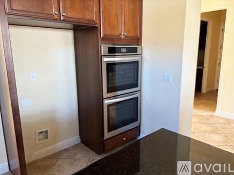 A kitchen with a black counter top and a stainless steel oven.