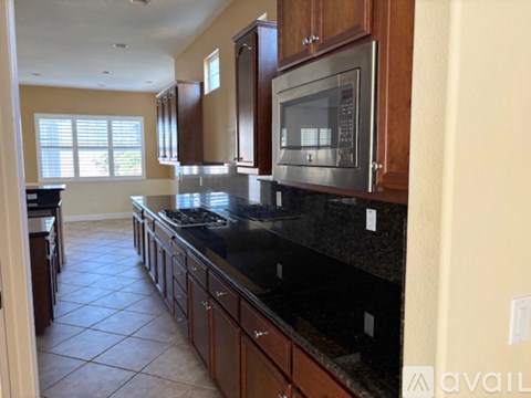 A kitchen with wooden cabinets and a black countertop.