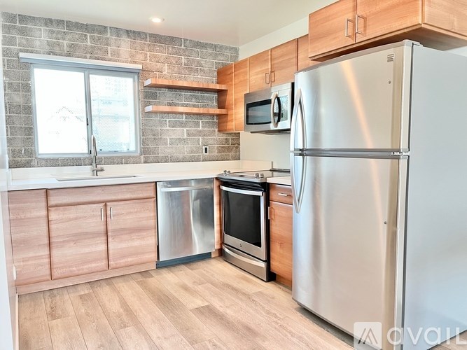 A kitchen with a refrigerator, oven, and microwave.