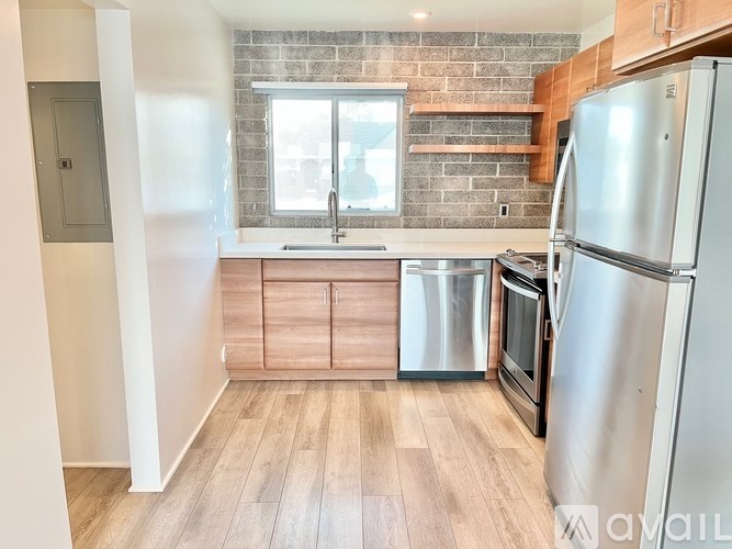 A kitchen with wooden floors and a brick wall.