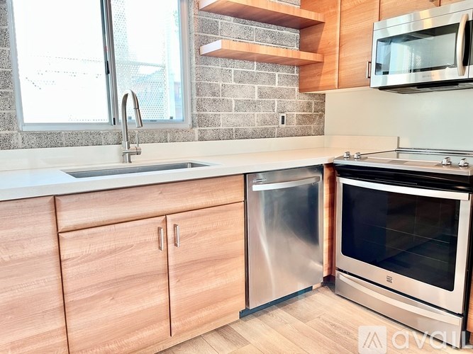 A modern kitchen with wooden cabinets and stainless steel appliances.