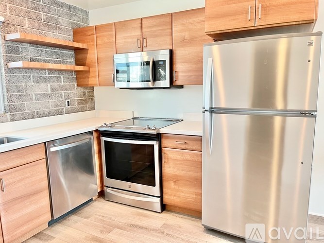 A kitchen with wooden cabinets and a stainless steel refrigerator.