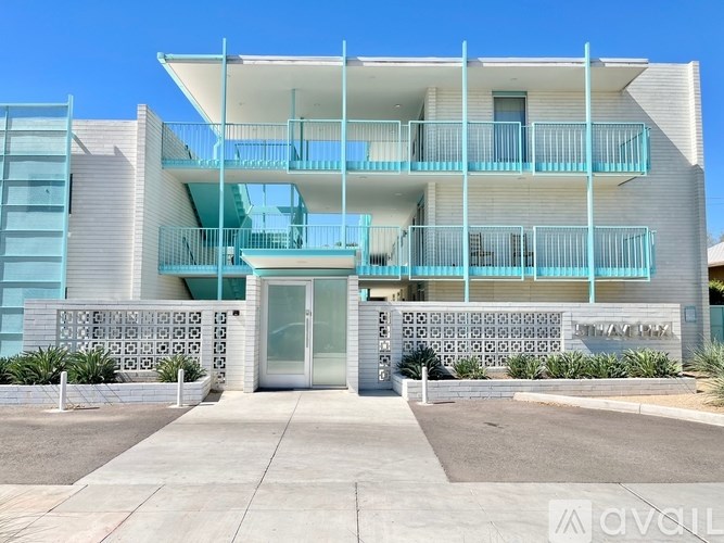 A modern building with a blue balcony and a white door.