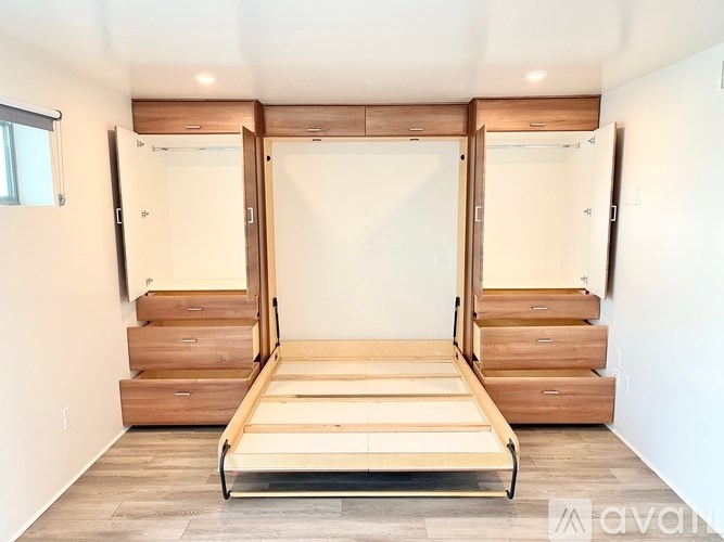 A bed with drawers underneath it in a room.