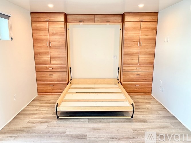 A bedroom with a bed, dresser, and wardrobe.