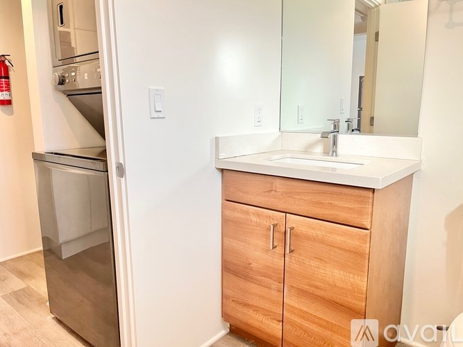 A kitchen with a wooden cabinet and a white sink.